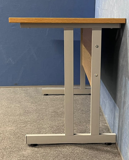 Oak straight desk on a blue wall and grey carpet