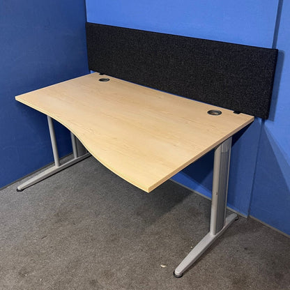 Wooden office desk with a black screen against a blue wall