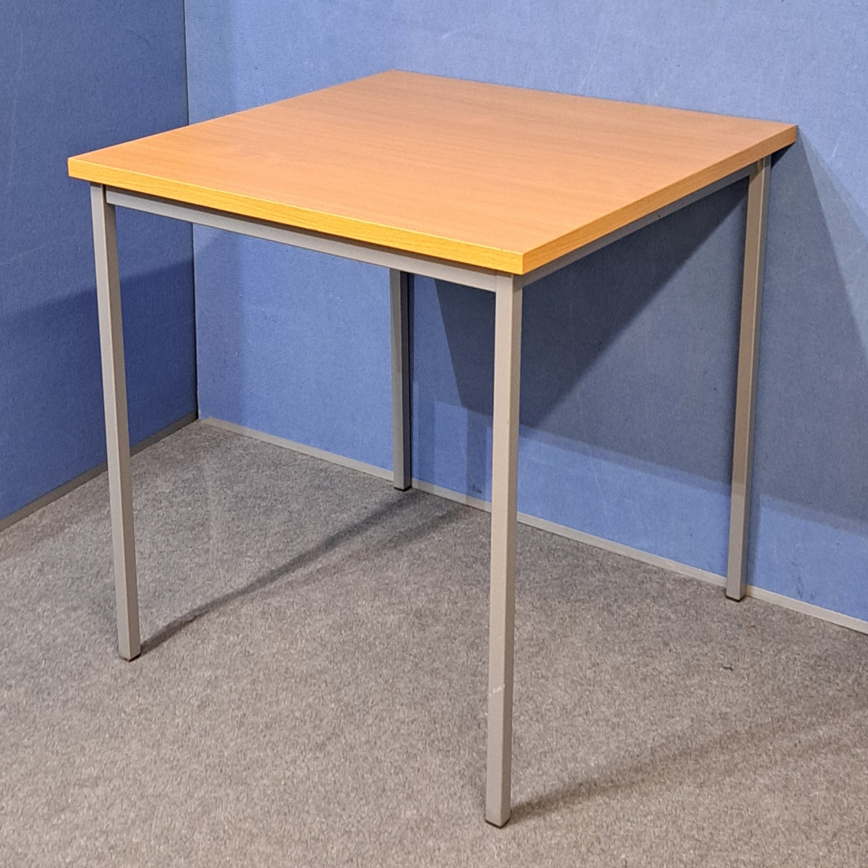Beech table on a blue wall and grey carpet