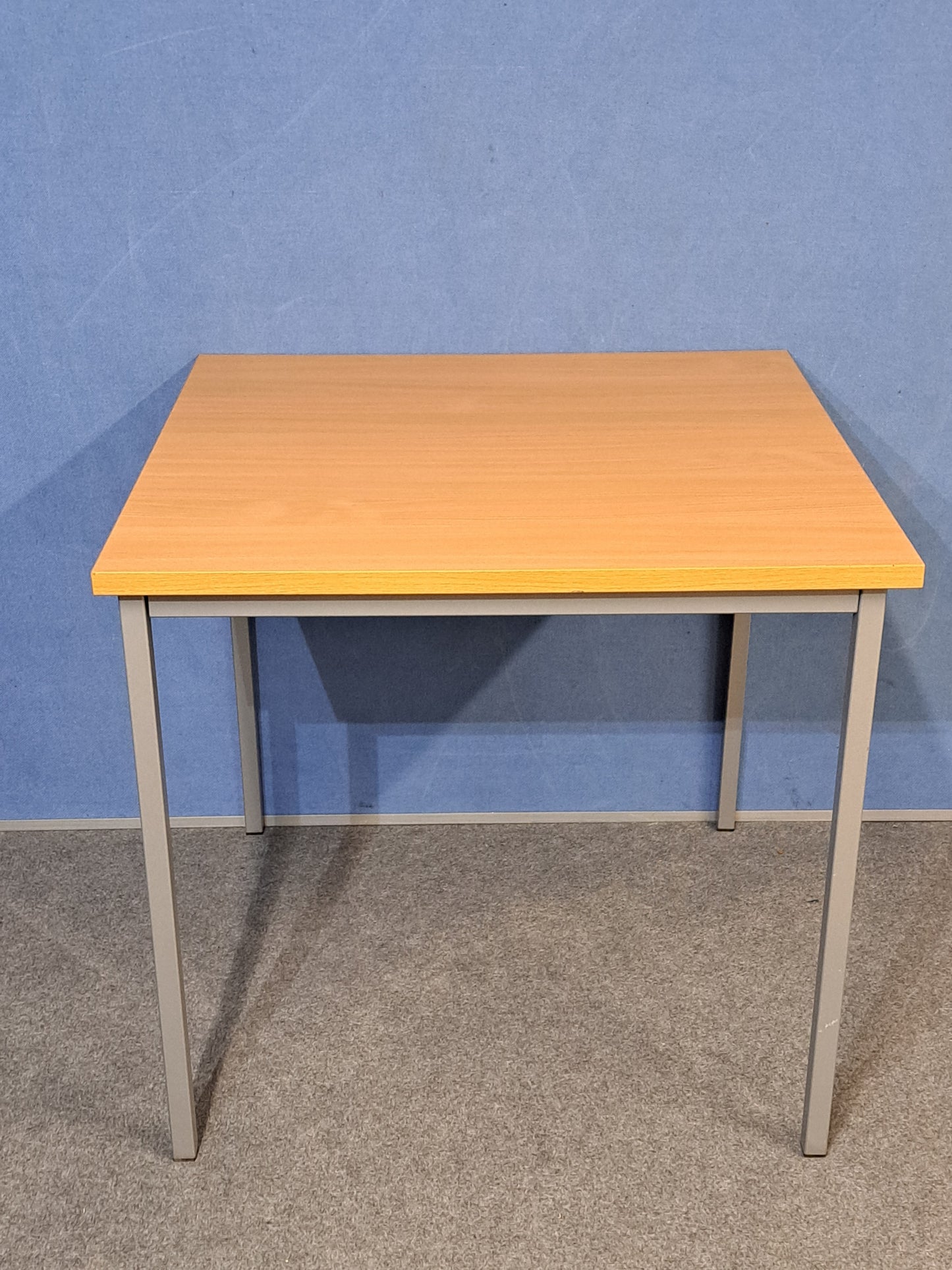 Beech table on a blue wall and grey carpet
