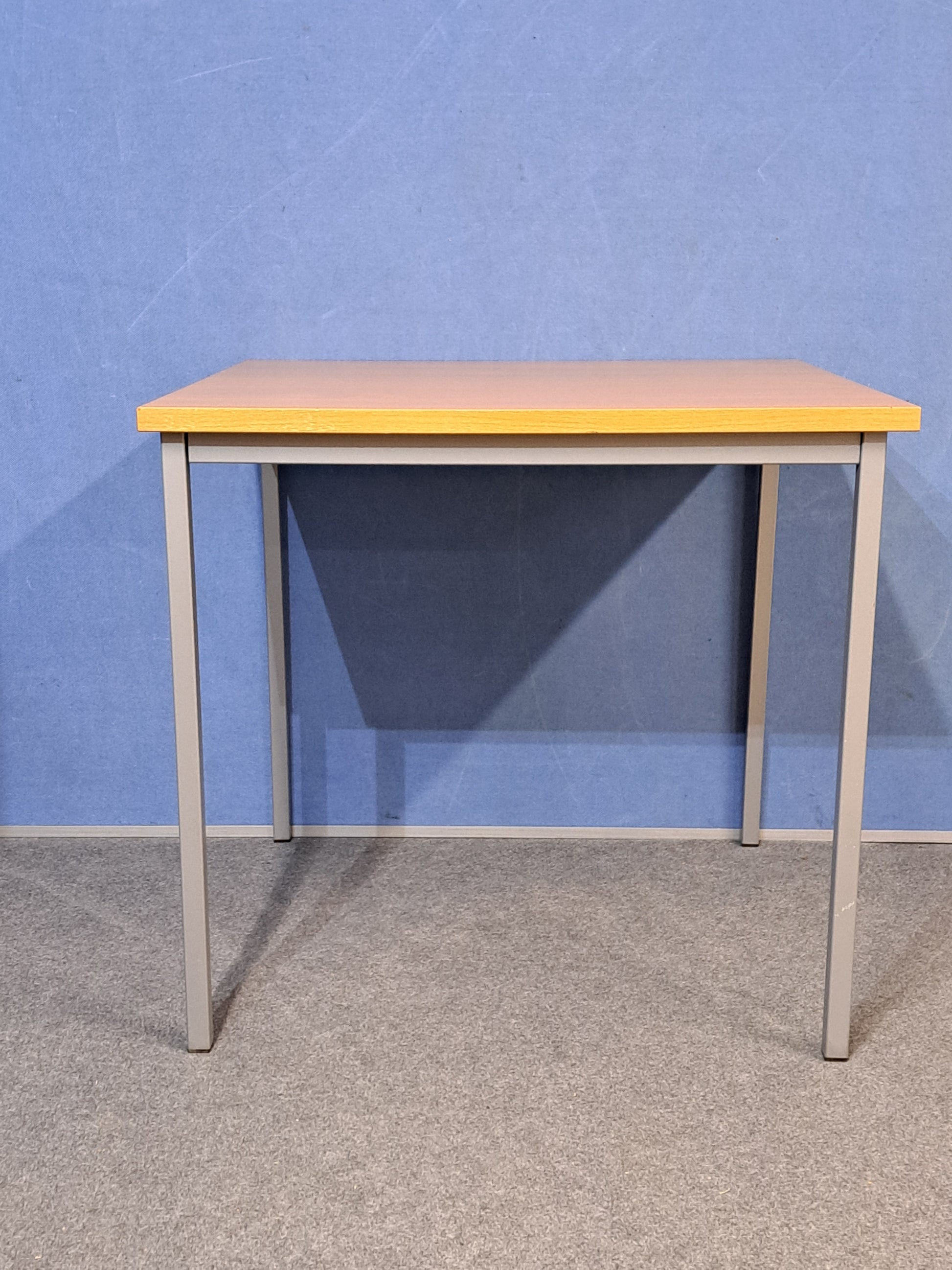 Beech table on a blue wall and grey carpet