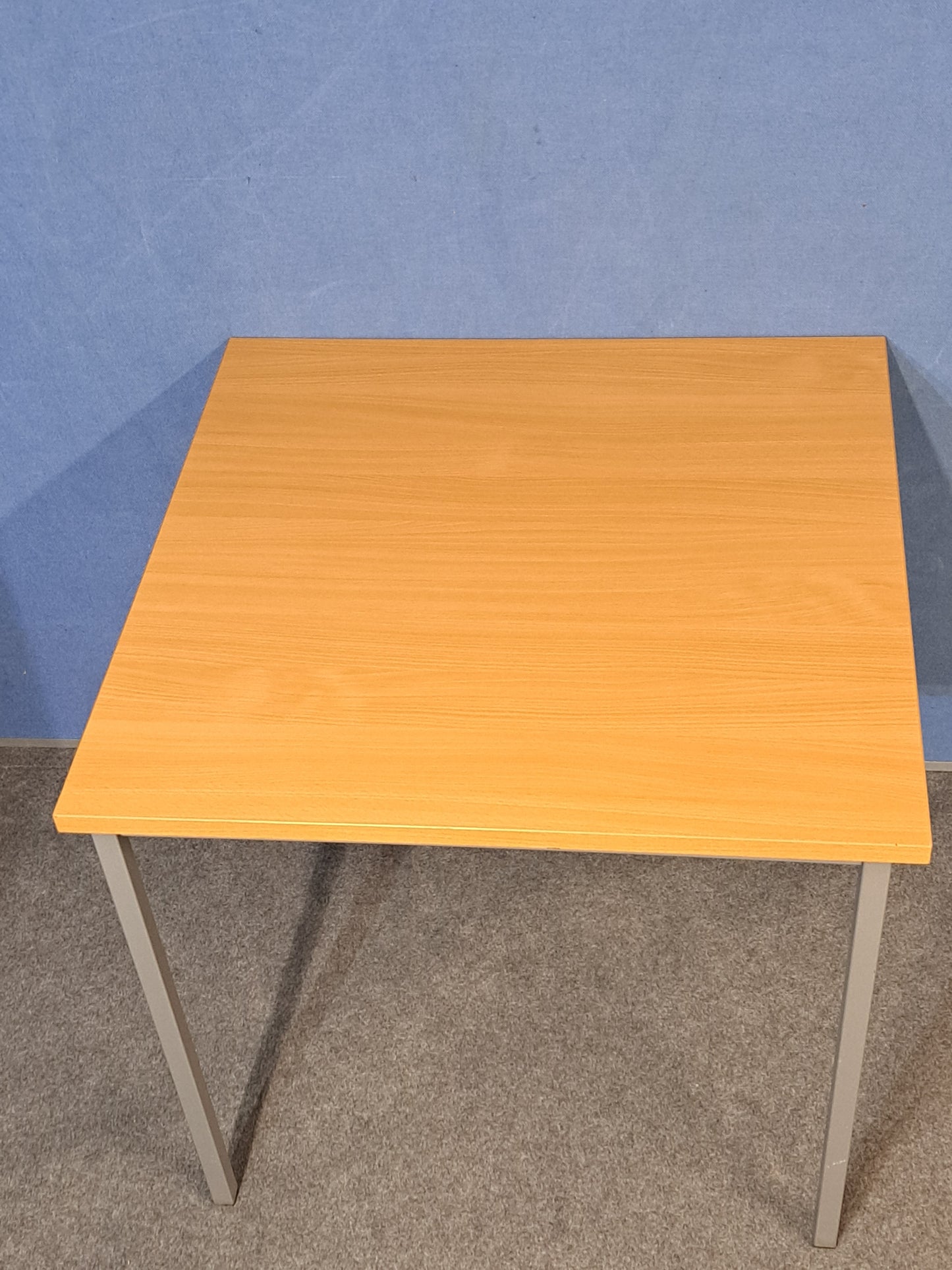 Beech table on a blue wall and grey carpet