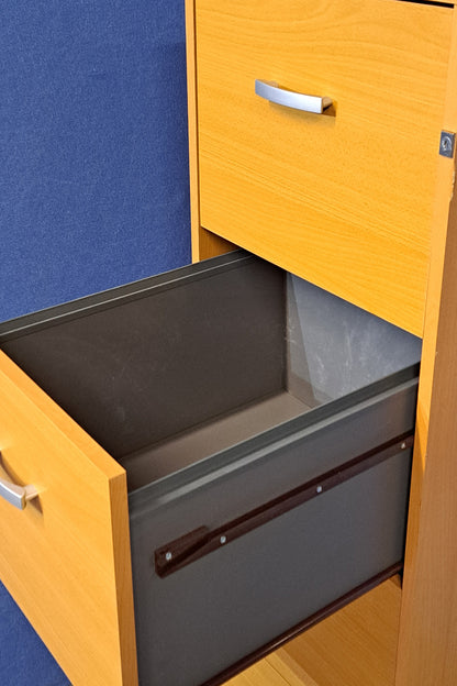 Beech filing cabinet on a blue a wall and grey carpet