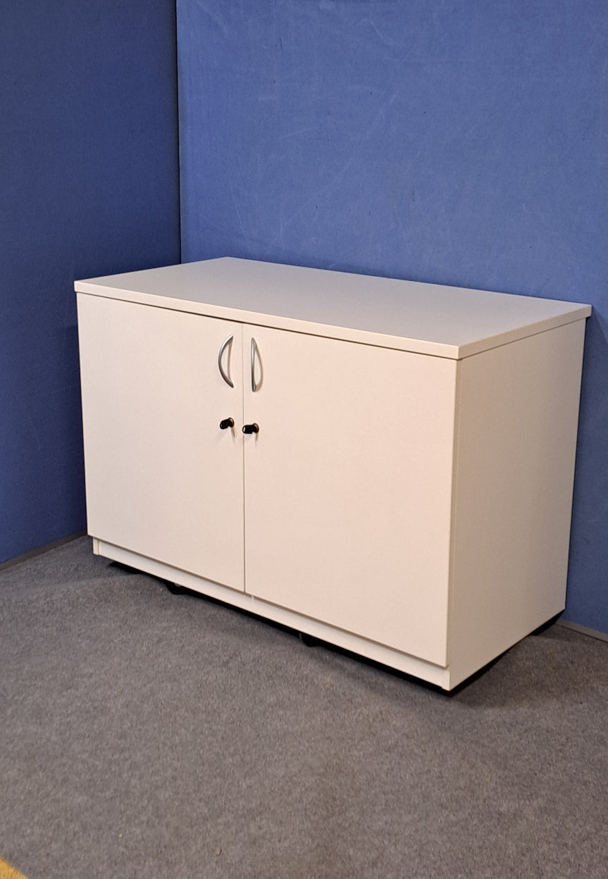 White cupboard on a blue wall and grey carpet