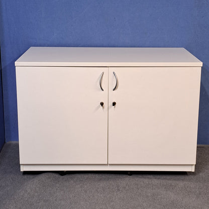 White cupboard on a blue wall and grey carpet